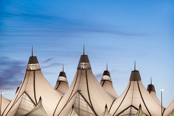 Glowing tents of DIA at sunrise. Denver International Airport well known for peaked roof. Design of roof is reflecting snow-capped mountains.
